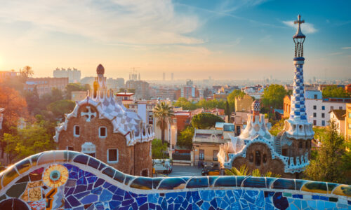 Barcelona city view from Guell Park with colorful mosaic buildings in tourist attraction Park Guell in the morning on sunrise. Barcelona, Spain